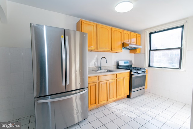 kitchen with tile walls, sink, light tile patterned floors, and appliances with stainless steel finishes