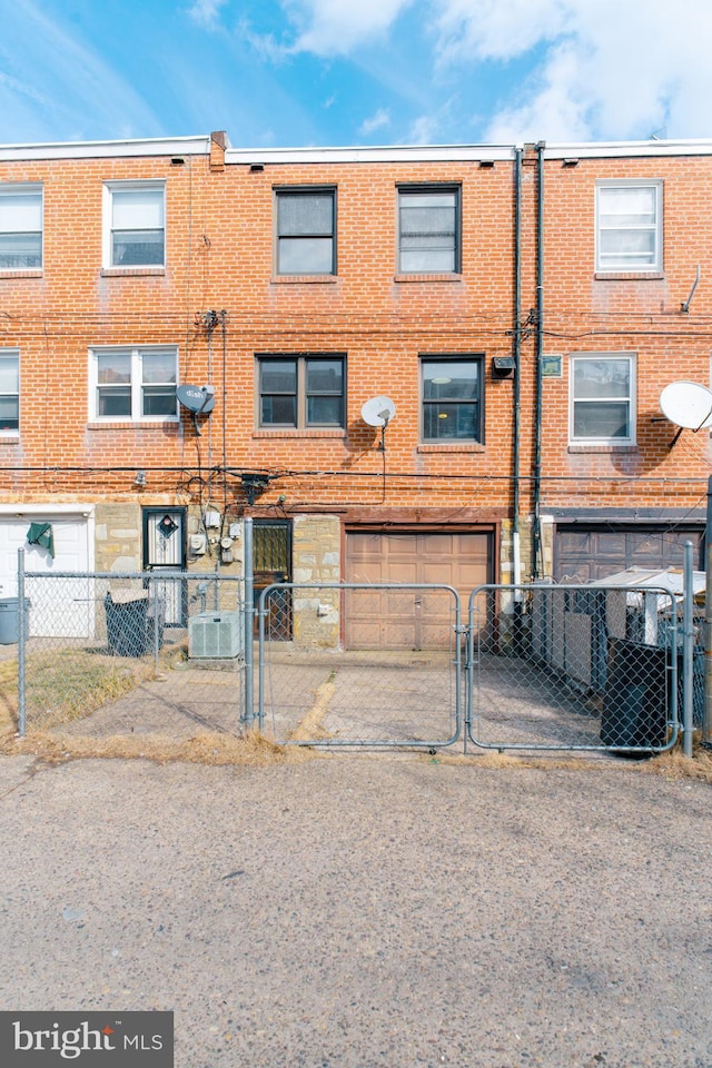 back of property featuring a garage and central AC