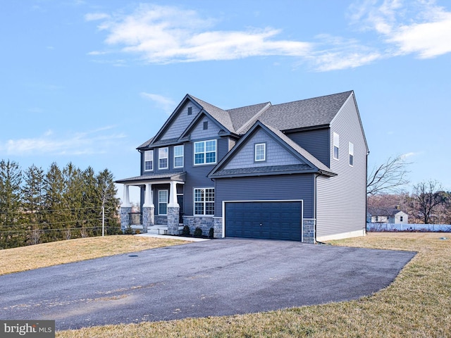 craftsman-style home featuring a porch, a garage, and a front yard