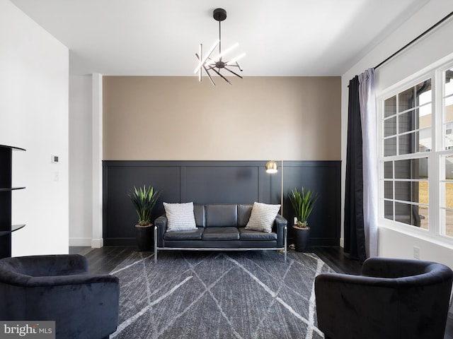 living room with an inviting chandelier and dark wood-type flooring