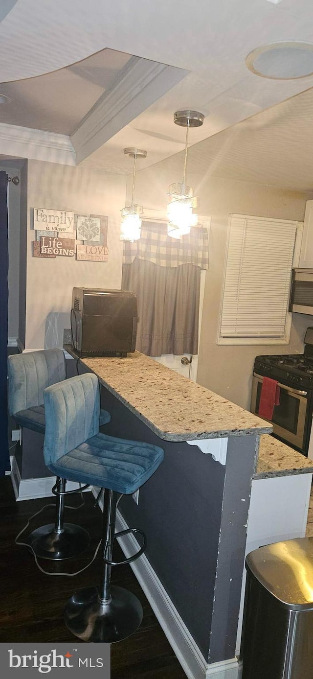 dining area featuring hardwood / wood-style flooring, ornamental molding, and bar area