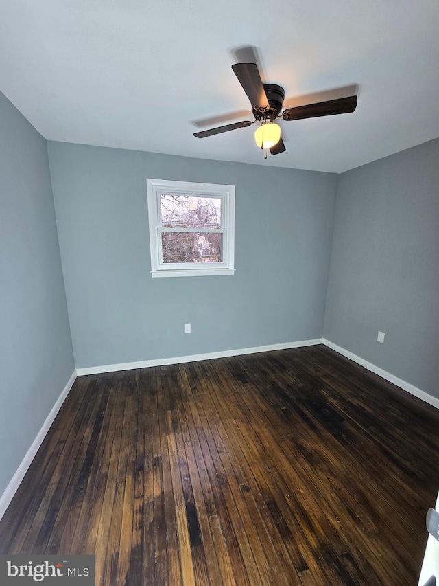 unfurnished room with dark hardwood / wood-style flooring and ceiling fan