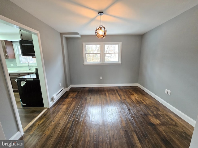 unfurnished dining area with sink, a baseboard heating unit, and dark wood-type flooring