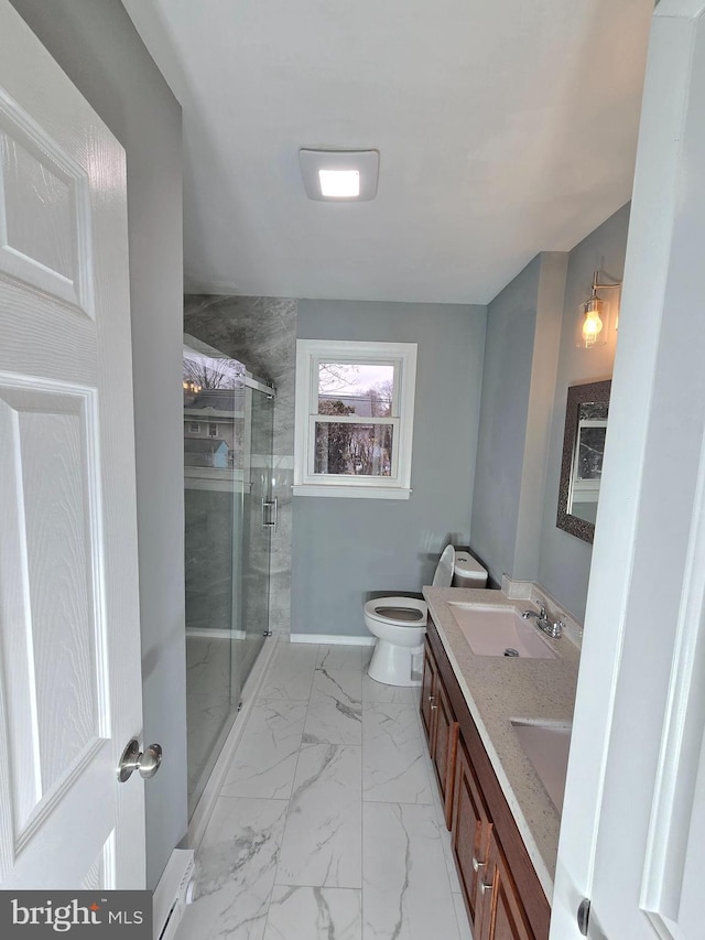 bathroom featuring vanity, a shower with shower door, and toilet