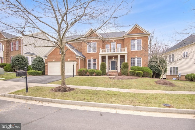 view of front of house featuring a balcony, a garage, and a front yard