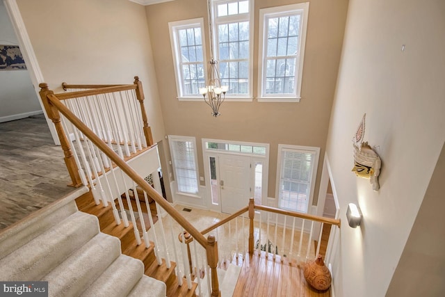 stairway with wood-type flooring and a high ceiling