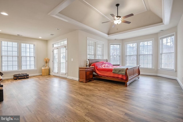 bedroom featuring a tray ceiling, ceiling fan, and hardwood / wood-style flooring