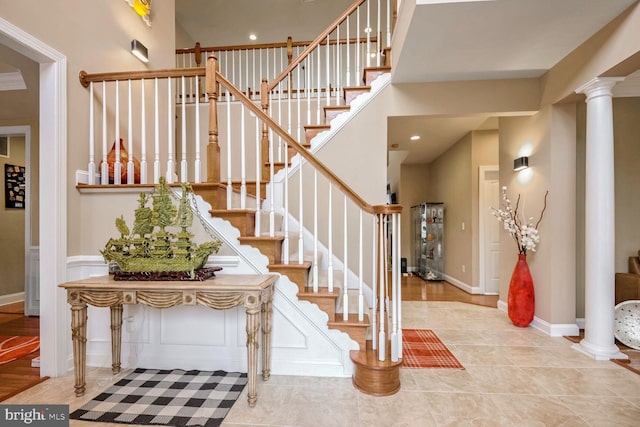 foyer featuring a towering ceiling and decorative columns