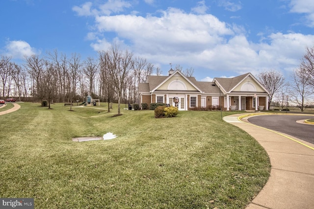 view of front of home featuring a front yard and a playground