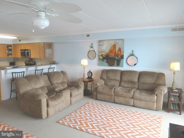 carpeted living room with ceiling fan