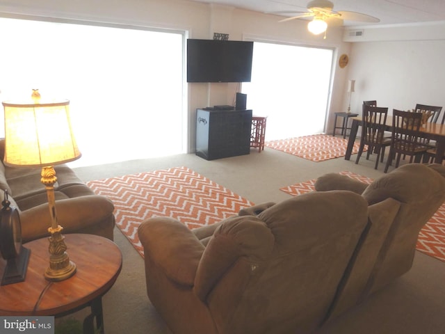 living room with plenty of natural light, carpet flooring, and ceiling fan