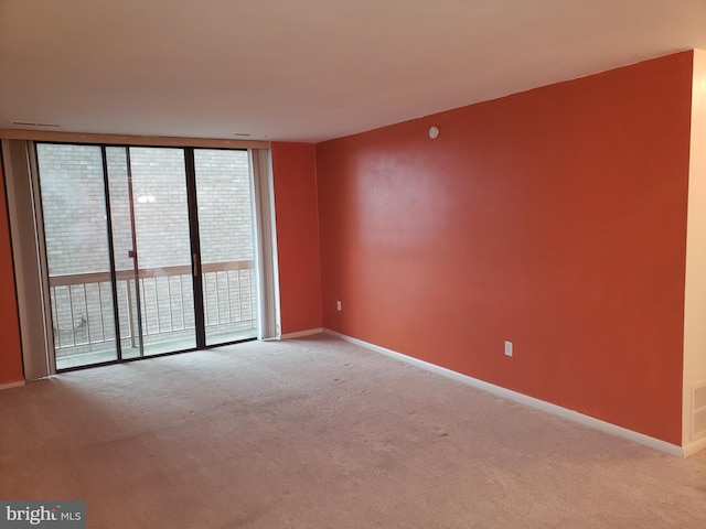 spare room with light colored carpet and floor to ceiling windows