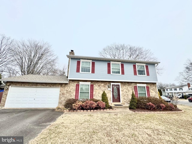 front of property with a garage and a front lawn