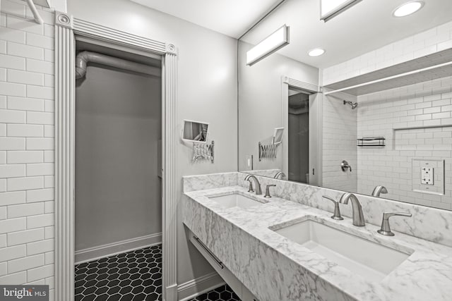 full bathroom with double vanity, recessed lighting, a shower, and a sink