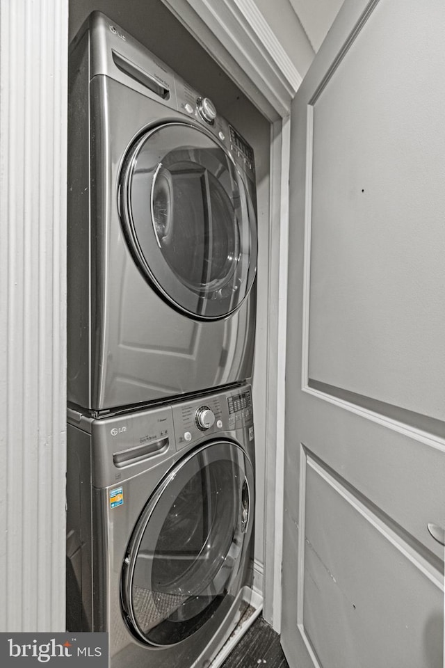 laundry room featuring stacked washer / drying machine and laundry area