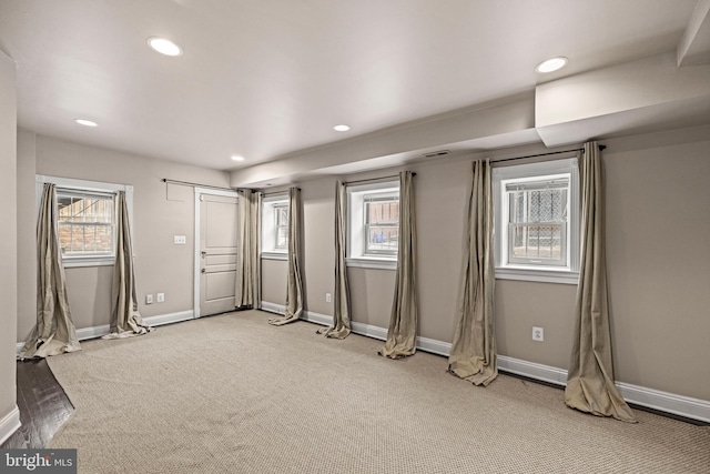 interior space with a healthy amount of sunlight, baseboards, and light carpet