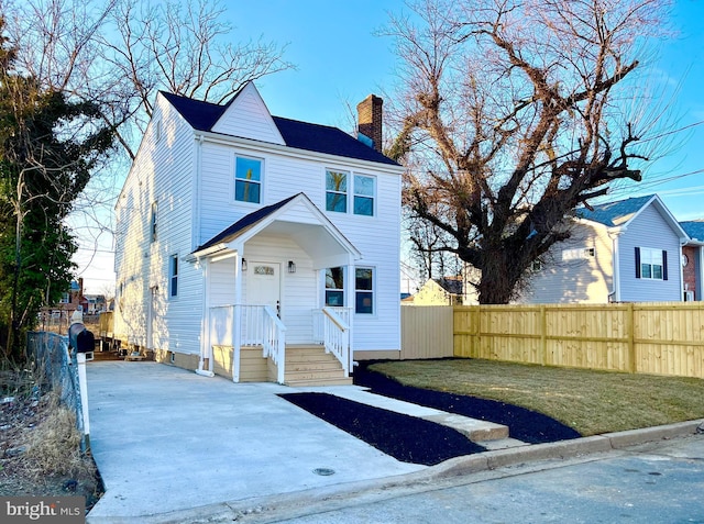 view of front of house with a chimney and fence