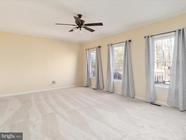 carpeted spare room featuring ceiling fan and ornamental molding