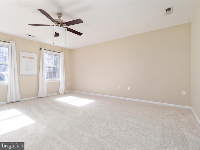 spare room featuring light carpet and ceiling fan