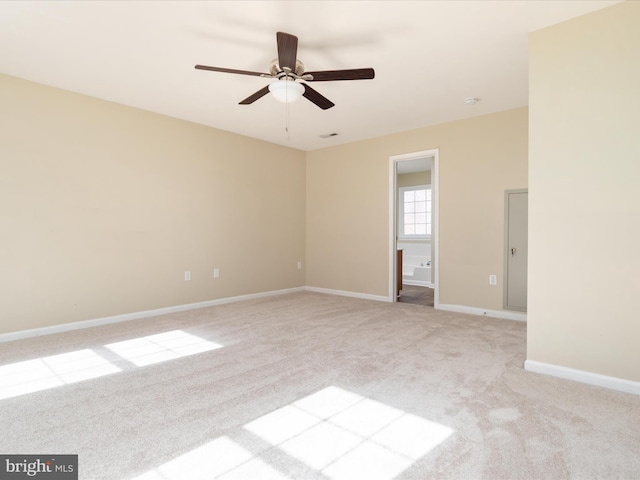 carpeted spare room featuring ceiling fan