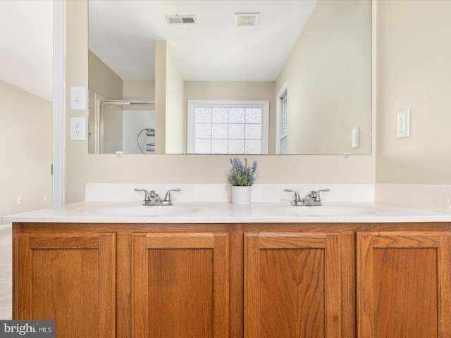 bathroom with vanity and a shower with door