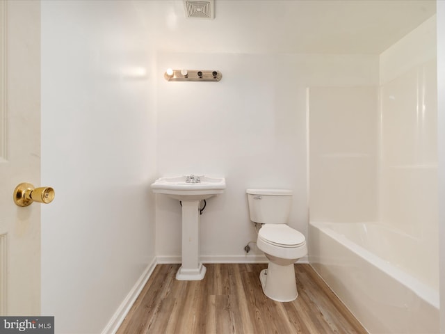 bathroom with toilet, separate shower and tub, and wood-type flooring