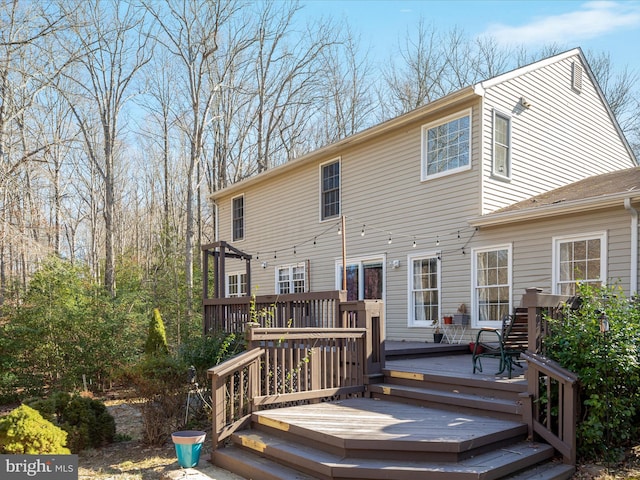 rear view of house with a deck and a pergola