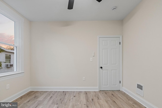 unfurnished room featuring cooling unit, ceiling fan, and light hardwood / wood-style flooring