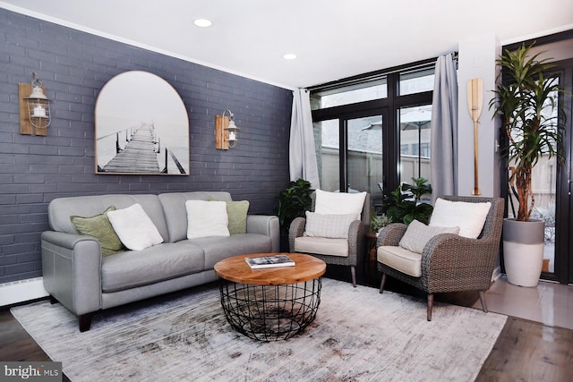 living room with brick wall and hardwood / wood-style floors