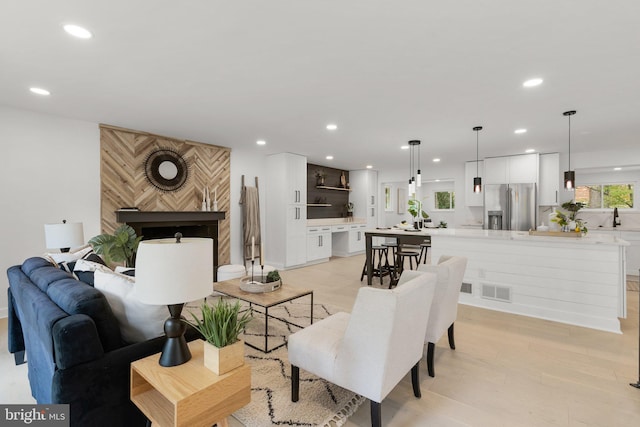 living room with sink and light hardwood / wood-style flooring