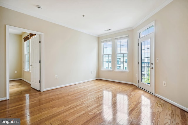 spare room featuring ornamental molding and light wood-type flooring