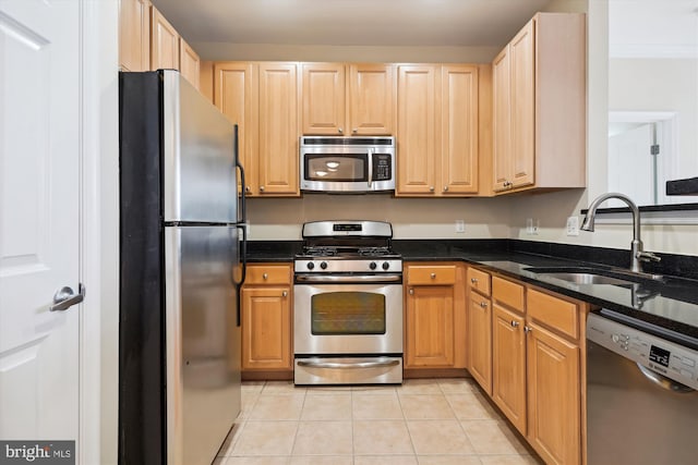 kitchen with sink, dark stone counters, light tile patterned floors, stainless steel appliances, and light brown cabinets