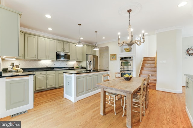 kitchen featuring dark countertops, a sink, light wood-style floors, stainless steel appliances, and backsplash