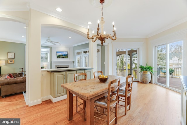 10002 Woodrow St, Vienna, VA 22181 - dining space with a fireplace, arched walkways, ceiling fan with notable chandelier, recessed lighting, and light wood-type flooring