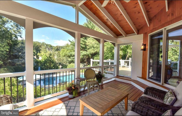sunroom / solarium featuring lofted ceiling with beams, wood finished floors, and wooden ceiling