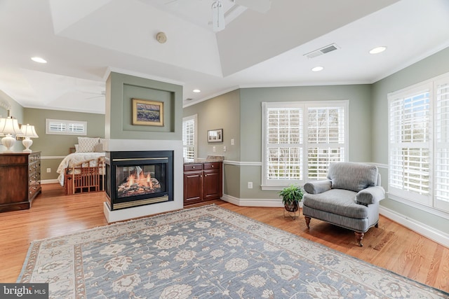 sitting room with baseboards, ceiling fan, visible vents, and light wood-style flooring