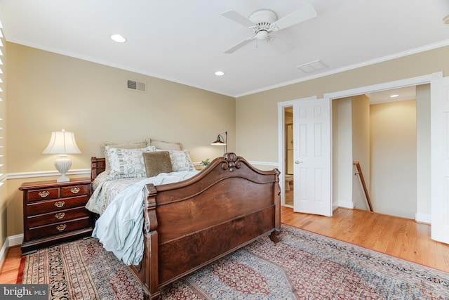 bedroom featuring visible vents, ornamental molding, and wood finished floors
