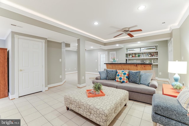living room with a ceiling fan, baseboards, wet bar, light tile patterned floors, and visible vents