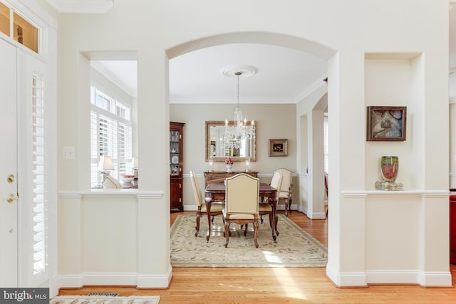 10002 Woodrow St, Vienna, VA 22181 - dining room featuring crown molding, arched walkways, and light wood-style flooring