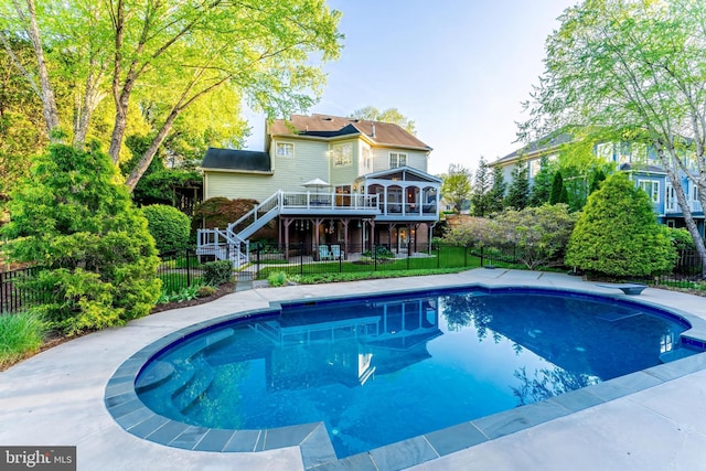 rear view of property featuring fence private yard, a fenced in pool, stairway, and a deck