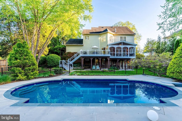 view of swimming pool featuring a fenced backyard, a diving board, a deck, and stairway