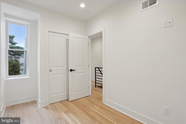 unfurnished bedroom with light hardwood / wood-style floors and a closet