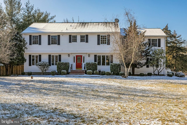 colonial-style house with fence