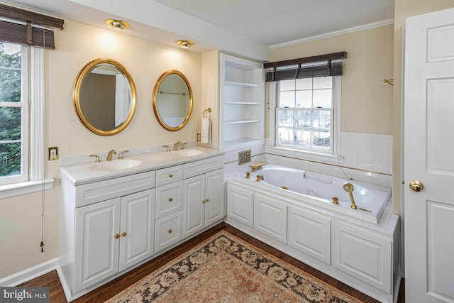 bathroom with a relaxing tiled tub, vanity, hardwood / wood-style floors, and a wealth of natural light