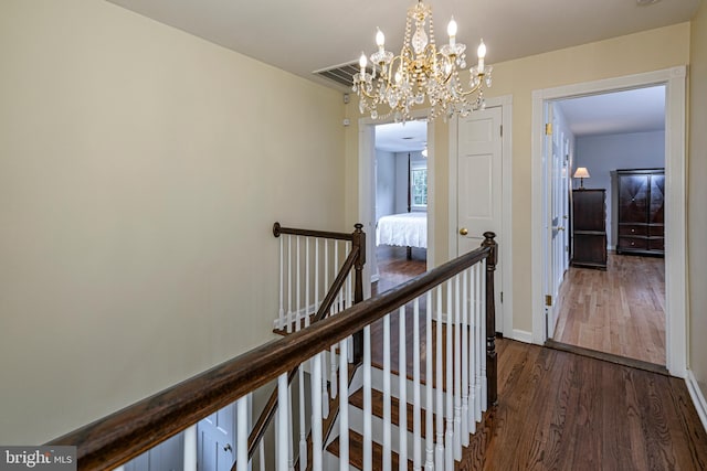 corridor featuring a chandelier and dark wood-type flooring