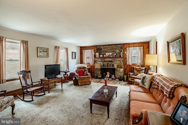 living room featuring a stone fireplace and carpet