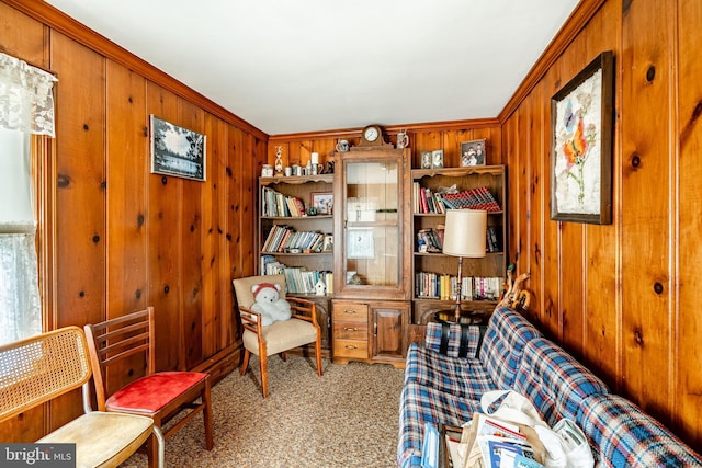 sitting room with light carpet and wood walls