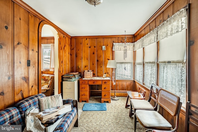 carpeted home office with wood walls