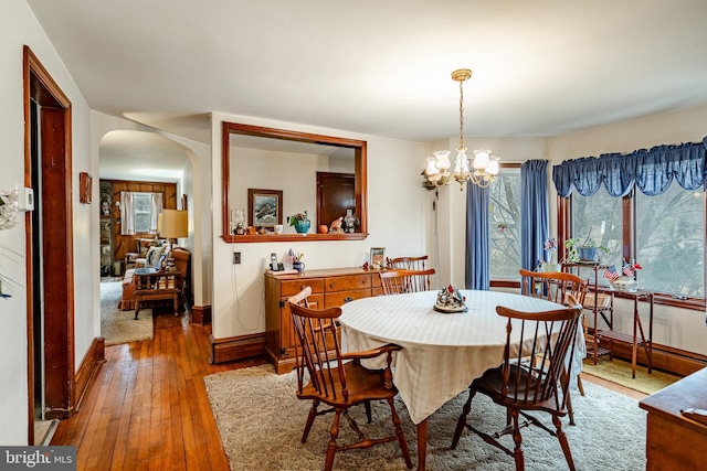 dining room featuring a healthy amount of sunlight, hardwood / wood-style floors, and a chandelier