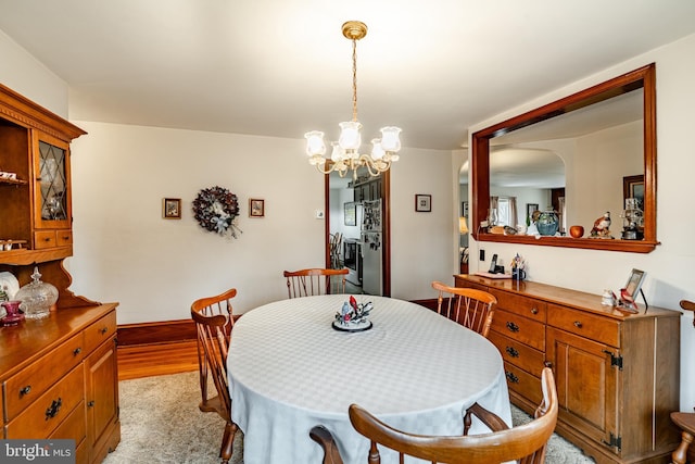 dining room with a chandelier and light wood-type flooring